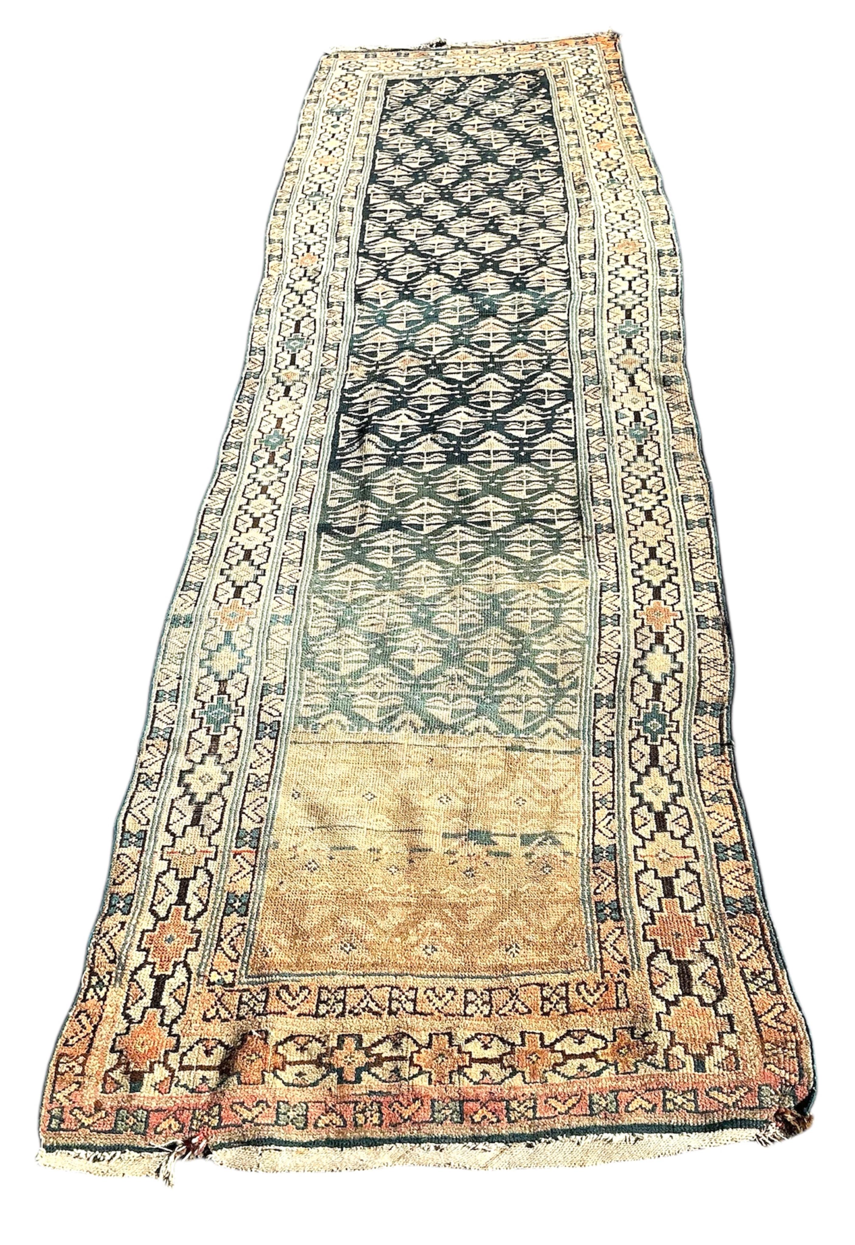 An antique Caucasian blue ground runner, heavily worn and faded, 342 x 96cm